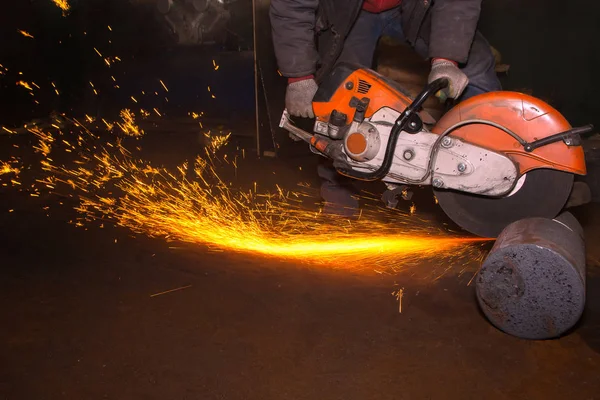 Arbeiter sägt Metall mit großer Kreissäge in den Händen — Stockfoto