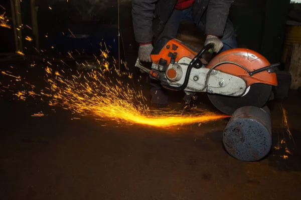 Nahaufnahme Arbeiter sägt Metall mit einer großen Kreissäge in den Händen der Fabrikhalle, Funken — Stockfoto