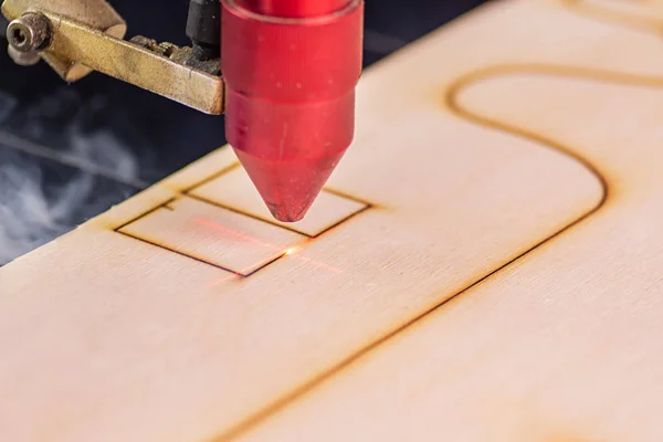 Graveur laser travaillant et gravant la planche en bois — Photo