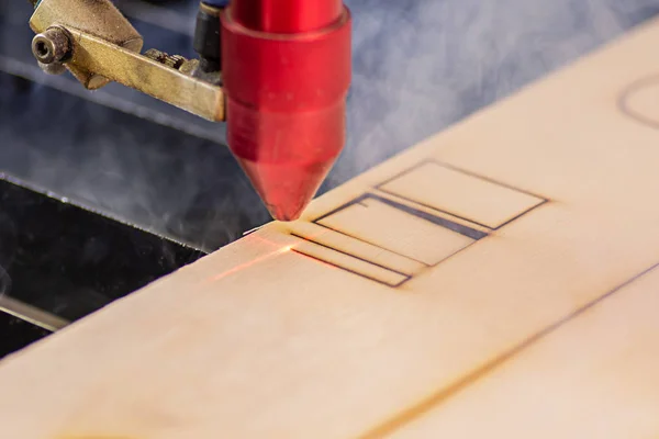 Laser engraver working and engraving wooden board with smoke — Stock Photo, Image