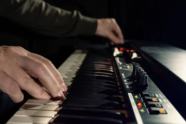 Close-up de mão pessoa tocando um teclado de piano em holofotes — Fotografia de Stock
