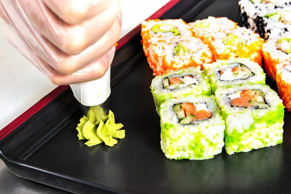 Zaostřená šéfkuchařských rukou kutálel sushi na kuchyni — Stock fotografie