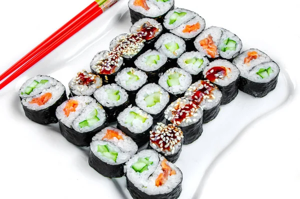 特写的沙片寿司套装，用筷子卷在白盘上 — 图库照片