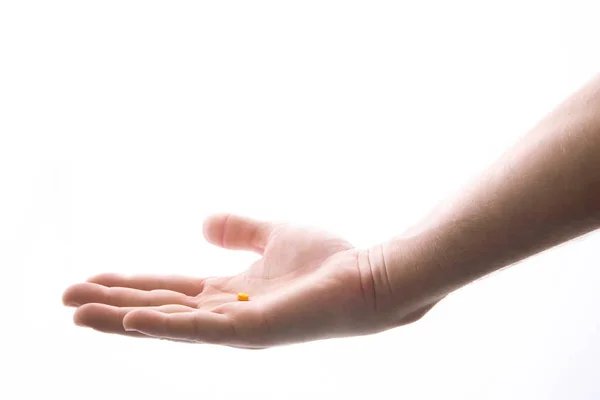 1錠の錠剤を持つ人間の手、白で隔離 — ストック写真