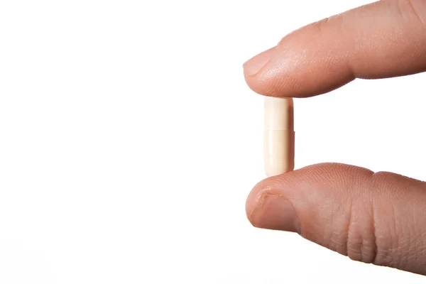 Mano humana con una pastilla, aislada en blanco —  Fotos de Stock