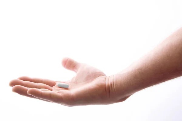 Mano humana con una pastilla, aislada en blanco —  Fotos de Stock