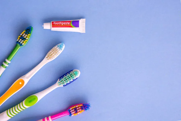 Petit dentifrice et plusieurs brosses à dents de vue du dessus sur bleu — Photo