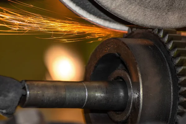 closeup Grinding machine, grinding with sparks a gear wheel in the automotive industry