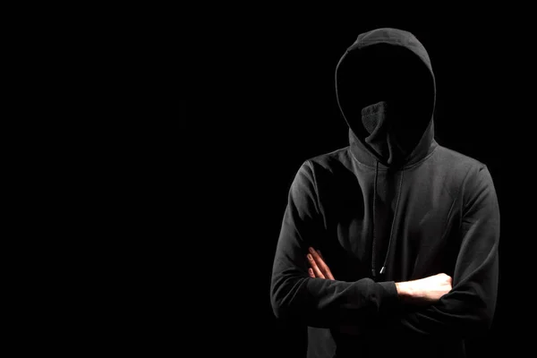 Ansiktslösa mannen i hoodie stående isolerade på svart — Stockfoto