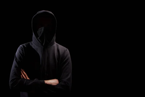 Hombre sin rostro en sudadera con capucha de pie aislado en negro —  Fotos de Stock