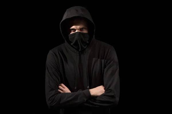 Hombre sin rostro con los ojos abiertos en sudadera con capucha de pie aislado en negro —  Fotos de Stock