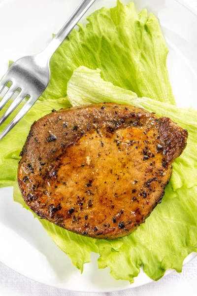 Стейк м'ясо з листям салату і виделкою в білій тарілці — стокове фото