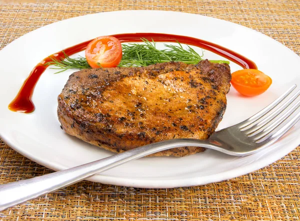 Мясо стейк с помидорами и салатом лист салата и вилка в белой тарелке — стоковое фото