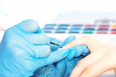 Güzellik salonunda sağlıklı doğal kadın tırnakları closeup. Manikürcü el boyama istemci çivi.