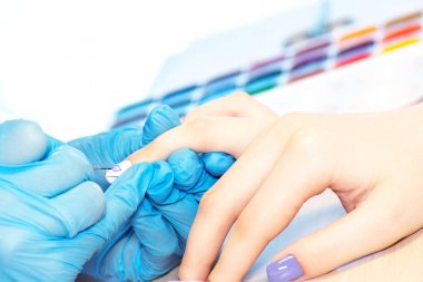 Güzellik salonunda sağlıklı doğal kadın tırnakları closeup. Manikürcü el boyama istemci çivi.