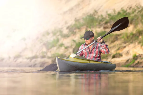 Sportler genießen schöne Zeit auf dem Fluss. starker Mann beim Kanufahren auf dem Fluss mit Sonnenlicht — Stockfoto