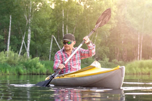 Sportler genießen schöne Zeit auf dem Fluss. starker Mann beim Kanufahren auf dem Fluss mit Sonnenlicht — Stockfoto