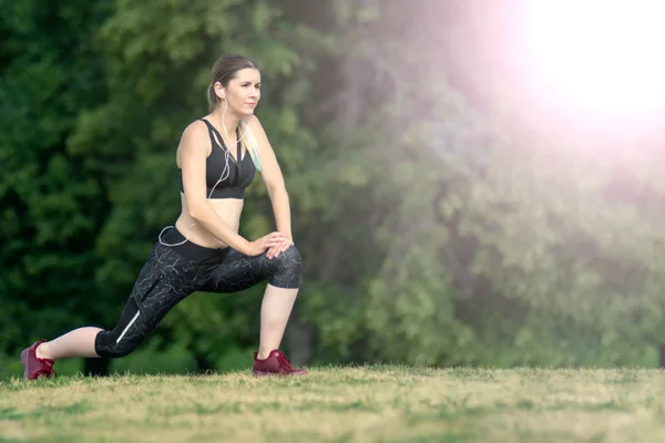 Vue latérale femme s'étire avant de courir dans la ville. Concept de forme physique et style de vie . — Photo