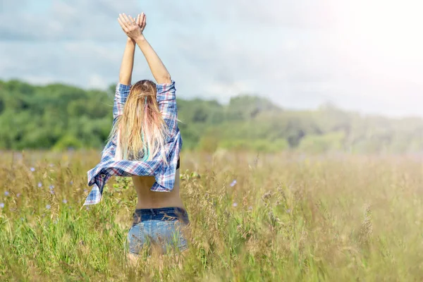 Feliz hermosa chica en el campo floreciente disfrutando del sol y las flores —  Fotos de Stock