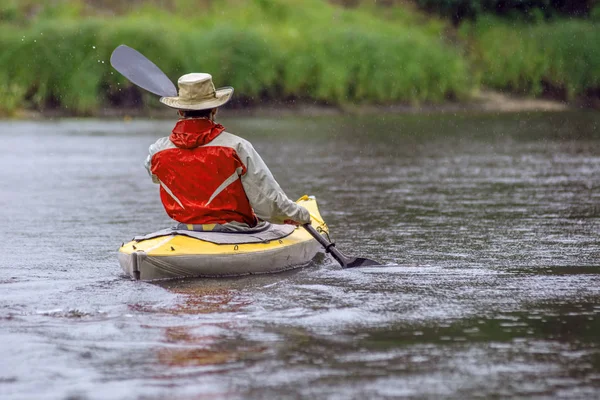 Retrato vista trasera kayak en sombrero redondo en el paisaje del río de verano con fuertes lluvias —  Fotos de Stock