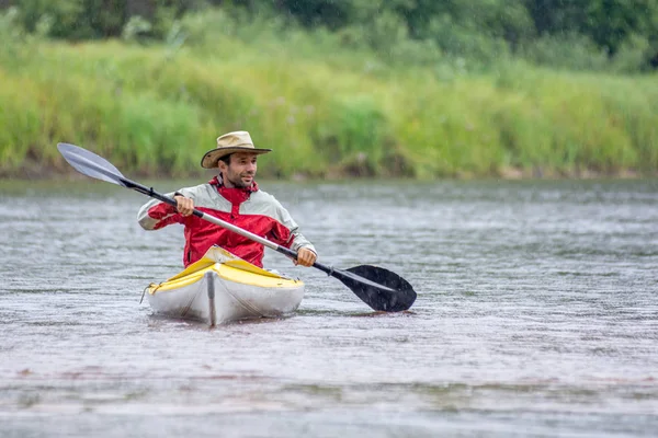 Retrato vista frontal kayak en sombrero redondo en el paisaje del río de verano con fuertes lluvias —  Fotos de Stock