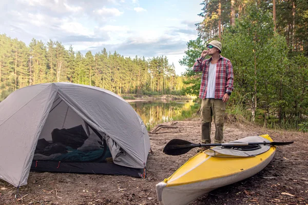 Man poserar och röker nära utomhus Camping tält och gula kajak — Stockfoto