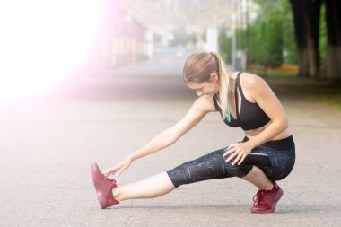 Yan görünüm kadın şehirde koşmadan önce germe olduğunu. Fitness ve yaşam tarzı kavramı.