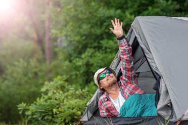 bir şapka ve güneş gözlüğü bir çadırda yalan ve bir puro sigara adam