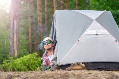 bir şapka ve güneş gözlüğü bir çadırda yalan ve bir puro sigara adam