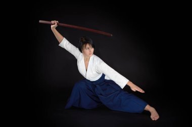 Geleneksel samuray hakama kimonosundaki Aikido ustası kadın. Bambu boken ile dövüşmeyi öğrenmek. Aikido Öğrenme Konsepti
