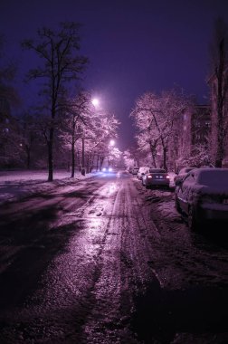 Karlı yol kar yağışı ile gece şehirde. Kış ağaçlar