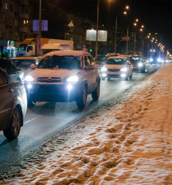 Karlı yol gece trafik ile. Gece şehri