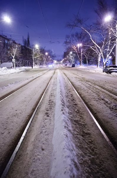 雪路的中心与铁轨 夜间城市与夜间交通 — 图库照片