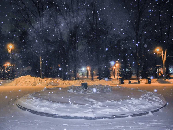 冬夜の公園 降雪とオレンジ色の光のランタン ストック写真