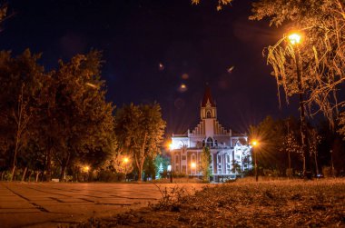 Güzel bir kilise ve parlayan fener ile gece park peyzaj