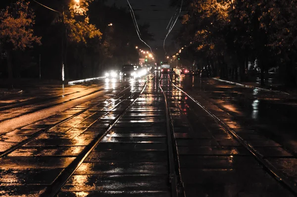 路的中心有铁轨 夜城市与夜交通在雨之下 — 图库照片