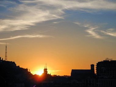 Güneş şehrin kilise kubbeleri arkasında gizler. Gün batımı kentsel peyzaj.