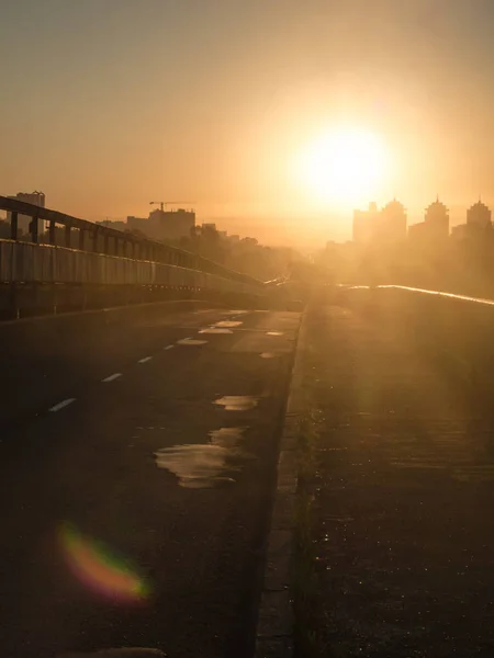 Dawn on the road towards the Sun. Dazzling morning sun