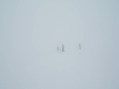 Buzlu teleferik ile kalın sis içinde deneyimsiz kayakçı. Kayakçı karlı bir dağ siste