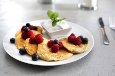 Meyve krep. Lezzetli kek ahududu meyveleri ile dekore edilmiş ve yoğurt sos ile yaban mersini, bir bölümünü