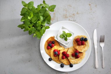 Güzel bir kahvaltı. Lezzetli kek ahududu meyveleri ile dekore edilmiş ve yoğurt sos ile yaban mersini, bir bölümünü