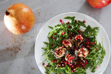 Patlıcan ruloları. Peynirli patlıcan roulades roket marul üzerinde nar ile servis.