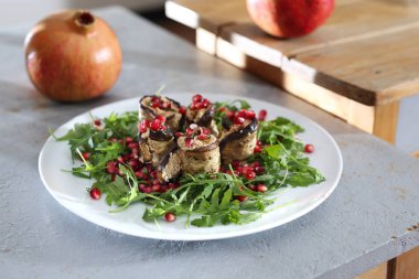 Sağlıklı beslenme. Peynirli patlıcan roulades roket marul üzerinde nar ile servis.