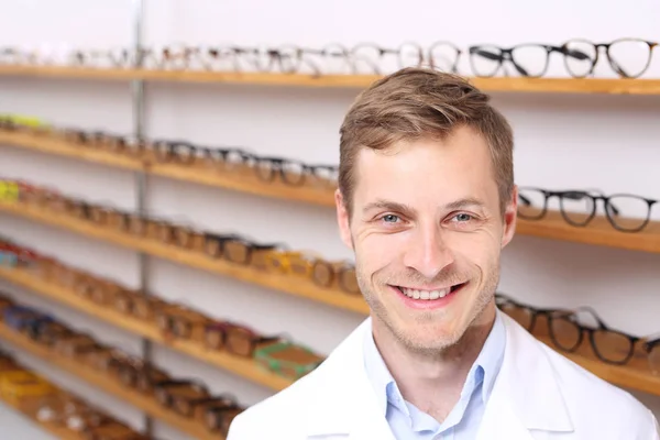 光学サロンで笑顔の眼鏡 光学サロンでハンサムな眼科医 — ストック写真