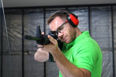 Çekim mesafeden. Yakışıklı adam trenler aralığı atıcılık spor çekim.