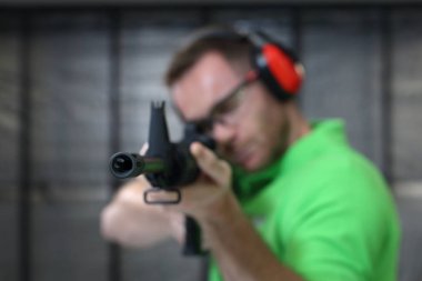 Atış poligonuna. Yakışıklı adam trenler aralığı atıcılık spor çekim.