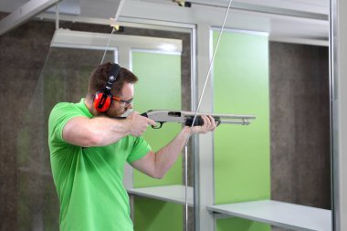 Atış poligonuna. Yakışıklı adam trenler aralığı atıcılık spor çekim.