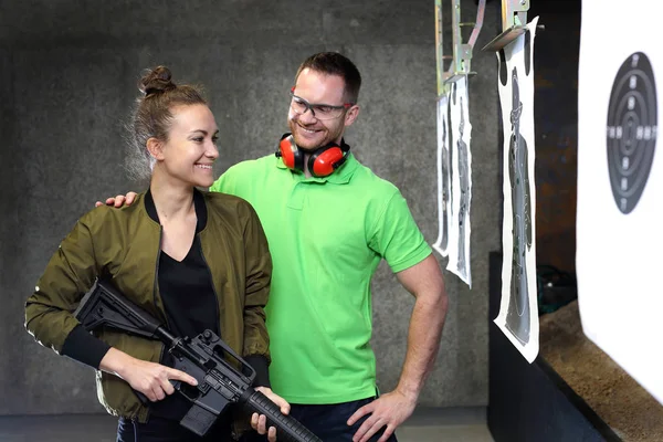 Ateş için öğrenme. Kadın silah bir eğitmen gözetiminde çekim mesafeden ateş eder.