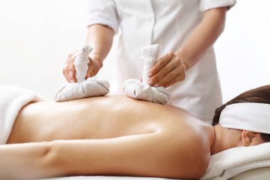 Sırt masajı bitkisel pul ile. Spa salonda rahatlayın.