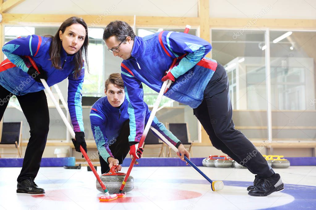 Curling games. The player is brushing the ice by directing the stone to the house
